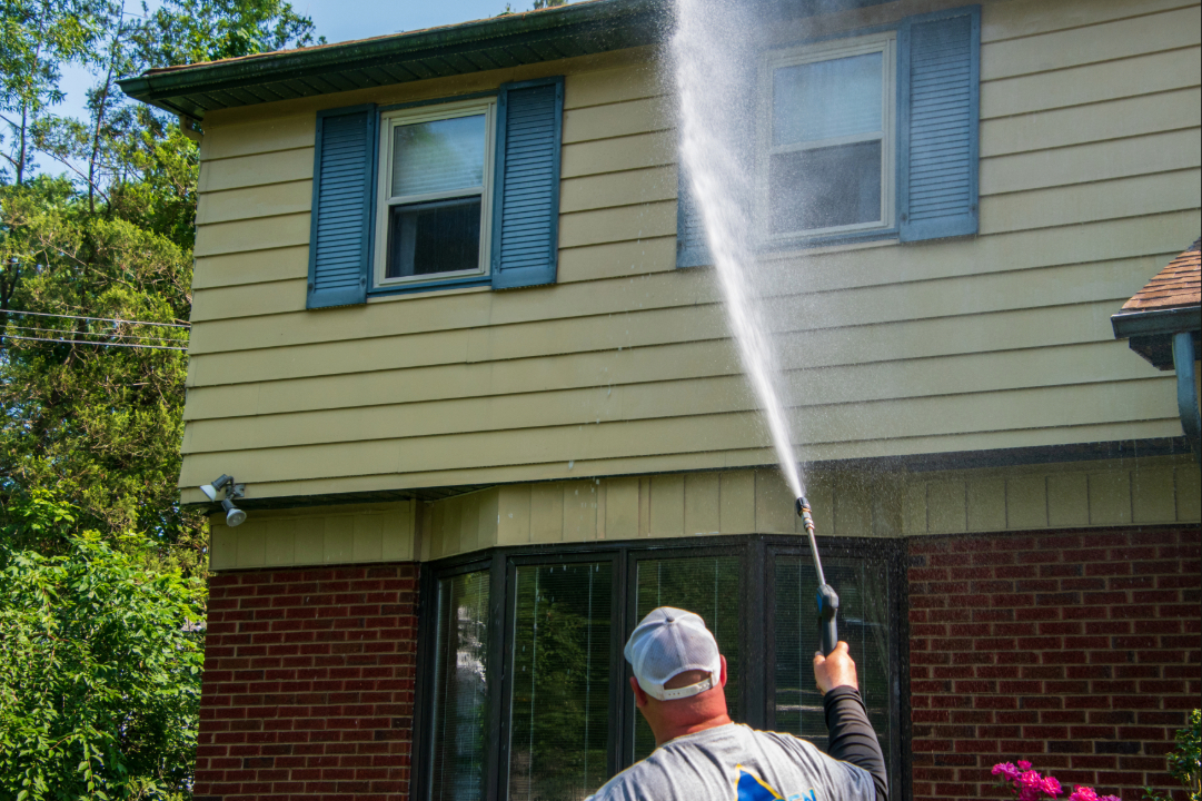 Contractor pressure washing a home